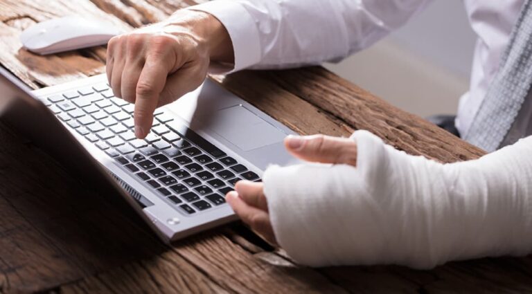Abbey Court Solicitors | AboutPerson with bandaged arm typing on laptop keyboard Person with bandaged arm typing on laptop keyboard