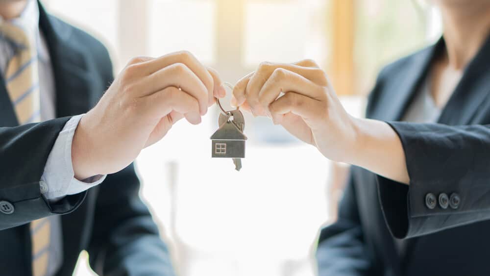 Abbey Court Solicitors | Transfers of EquityBusiness professionals exchanging house key in office Business professionals exchanging house key in office