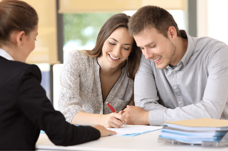 image Couple signing documents with financial advisor at desk