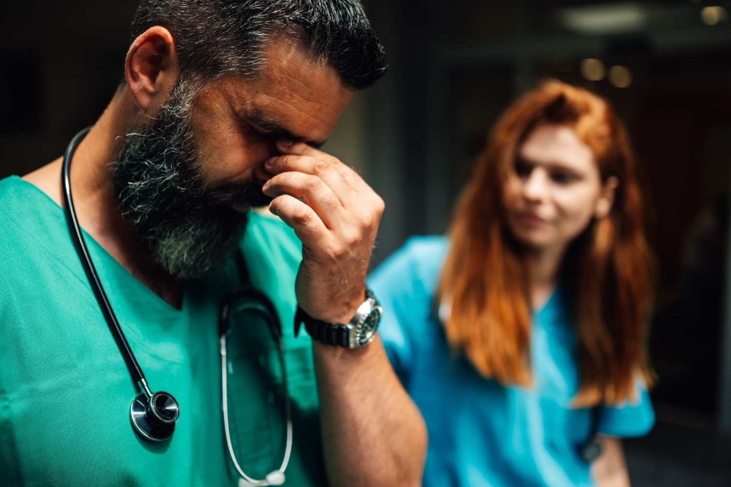Healthcare worker in scrubs with stethoscope looking concerned